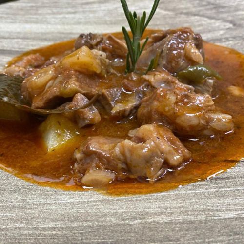 Caldereta de cordero con fondo de patatas